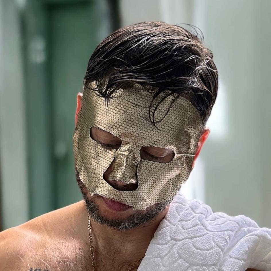 Man wearing a gold foil hydration sheet mask by MDRN.